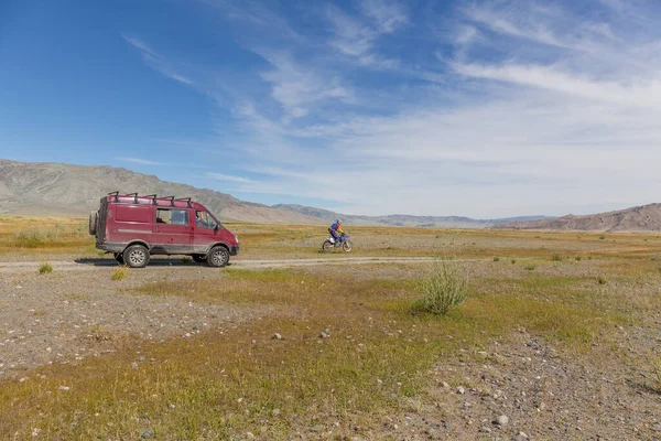 Car and motorbike on road in the desert mountain of the Mongolia