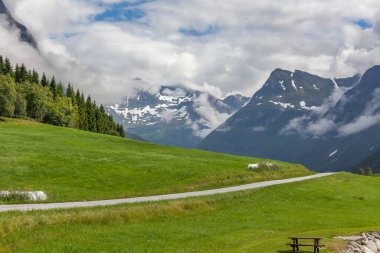 Norveç dağlarının bulutlarıyla çevrili gizemli bir vadiye giden yol. seçici odak