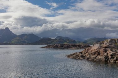 Norveç 'te gizemli bir fiyort. Dağlar ve sis, suyun üzerinde tek renkli güzel bir renkle süzülüyor. seçici odak