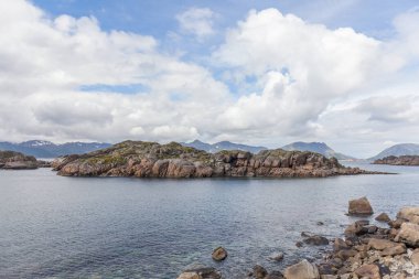 Norveç fiyortları ve dağları bulutlarla çevrili, gece yarısı güneşi, kutup günü, temiz suda fiyort yansıması. seçici odak.