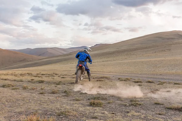 Altaj, Moğolistan - 11 Haziran 2017: Moğolistan tepelerinde motosiklet süren adam.