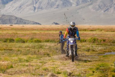 Altai, Moğolistan - 14 Haziran 2017: Moğol göçebesi çamura saplanan turistlere bakıyor.