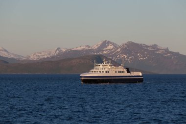 Kutup gününde Norveç fiyortlarını ziyaret etmek için gemi, gece yarısı güneşi. Norveç 'te karanlık bulutları olan gizemli bir fiyort. Dağlar ve sis suların üzerinde süzülüyor.