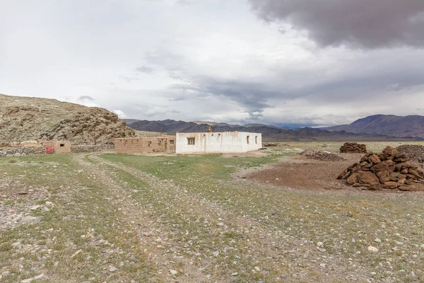 Winter dwelling and corral of nomadic people in the steppes of Mongolia. Pile of neatly complex dried manure in the foreground