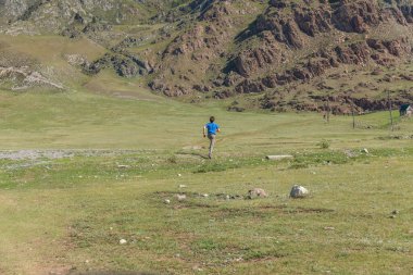 Bir adam Altai Dağları 'nın bozkırlarında yol boyunca koşuyor. Rusya.