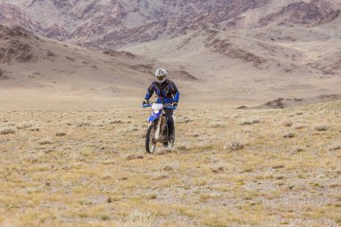 Altai, Moğolistan - 14 Haziran 2017: Moğolistan tepelerinde motosiklet süren adam