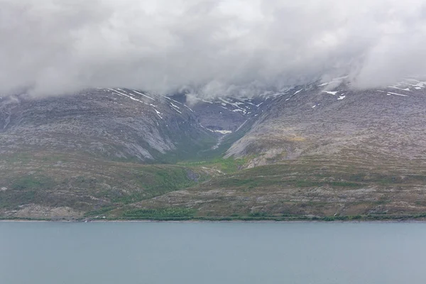 ノルウェーの神秘的なフィヨルドで 山々と霧が美しいモノクロの青い色で水の上にぶら下がっています 選択的焦点 — ストック写真