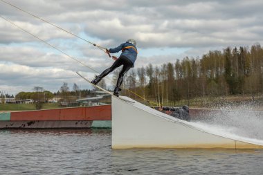 Fagersta, İsveç - Maj 01, 2020: İnsanoğlu wakeboard 'a aşırı atlıyor, etrafta bir sürü sıçrama oluyor