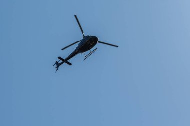 Avesta, İsveç - Maj 27, 2020: Mavi gökyüzünde helikopter. Güneş havadaki tozu aydınlatır. Aşağıdan görüntüle.