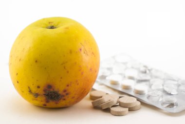 Elma ve haplar. Beyaz arka planda. Sebze ya da ilaç..