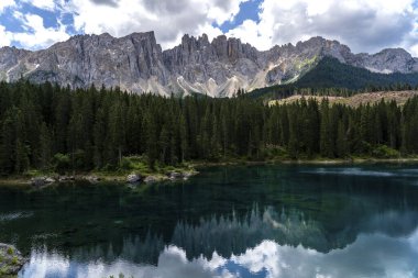 Kozalaklı ormanlarla çevrili kristal berrak göletin yansımasında Dolomitlerin resimli zirveleri. İtalya 'da Caresse Gölü. Manzaralı bir yer ve ünlü turistik bir yer. İlkel doğa.
