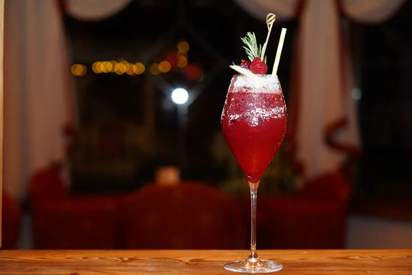 Raspberry alcohol cocktail on the bar. red cocktail garnished with raspberries on Christmas background — Stock Photo, Image