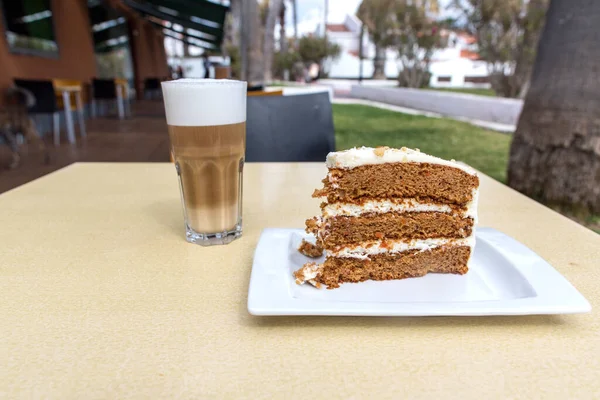 Carrot cake and coffee with milk. A typical carrot cake