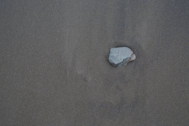 Arka plan, doku, dalgalı okyanus kumu dalgaları, siyah. Plaj kumunun dokusu. Siyah kumsal kumu. Puerto De La Cuz Plajı