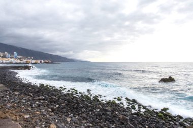 Puerto de la Cruz, Tenerife, Kanarya Adaları. Renkli evler, deniz ve volkanik kumsal manzarası. Tenerife 'deki siyah sahil.