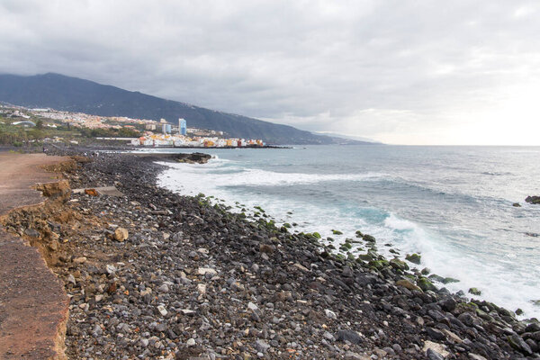 Puerto de la Cruz, Tenerife, Canary Islands - view of colorful houses, sea and volcanic-sand beach. Black beach in tenerife