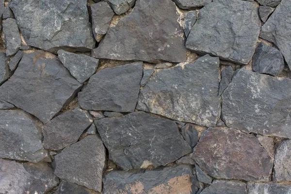 Taş dokusu. Taş döşemeli duvar. Kusursuz bir taş duvar. Kusursuz bir geçmişi var. Puerto De La Cruz, volkanik taş duvar.