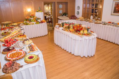 Şekerli büfe. Tatlı masasında meyveler ve diğer tatlılar. Hoş görünümlü tatlı sıraları güzel düzenlemeler içinde. Şölen masasında şekerler - yemek etkinliği sırasında çekilmiş fotoğraflar