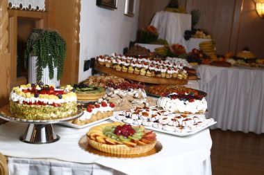 Şekerli büfe. Tatlı masasında meyveler ve diğer tatlılar. Hoş görünümlü tatlı sıraları güzel düzenlemeler içinde. Şölen masasında şekerler - yemek etkinliği sırasında çekilmiş fotoğraflar