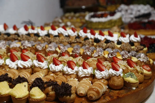 Buffet con dolci. frutta e altri dolci sul tavolo da dessert. Righe di dolci dall'aspetto gustoso in bellissimi arrangiamenti. Dolci sul tavolo del banchetto - foto scattata durante l'evento di catering — Foto Stock