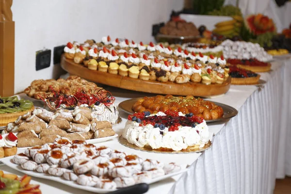 Buffet com doces. frutas e outros doces na mesa de sobremesa. Fileiras de saborosas sobremesas olhando em belos arranjos. Doces na mesa do banquete - foto tirada durante o evento de catering — Fotografia de Stock