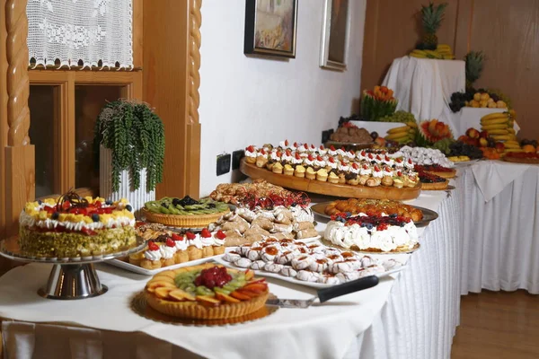 Buffet com doces. frutas e outros doces na mesa de sobremesa. Fileiras de saborosas sobremesas olhando em belos arranjos. Doces na mesa do banquete - foto tirada durante o evento de catering — Fotografia de Stock