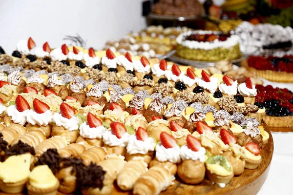 Buffet con dolci. frutta e altri dolci sul tavolo da dessert. Righe di dolci dall'aspetto gustoso in bellissimi arrangiamenti. Dolci sul tavolo del banchetto - foto scattata durante l'evento di catering — Foto Stock