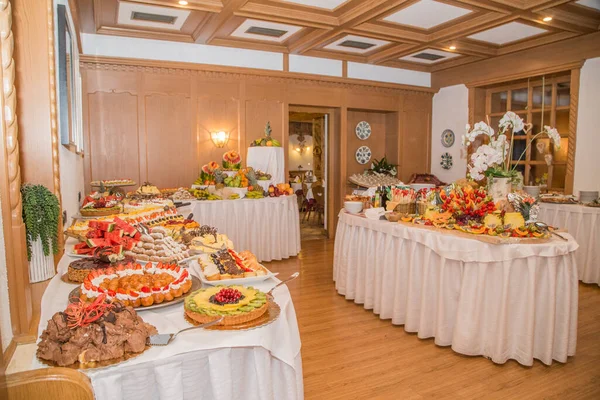 Buffet con dolci. frutta e altri dolci sul tavolo da dessert. Righe di dolci dall'aspetto gustoso in bellissimi arrangiamenti. Dolci sul tavolo del banchetto - foto scattata durante l'evento di catering — Foto Stock