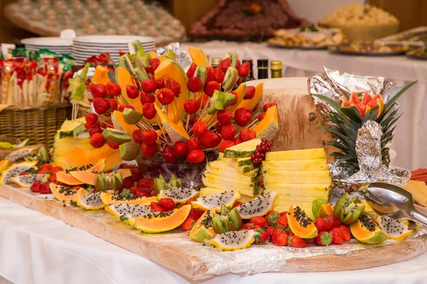 Dilimlenmiş taze meyve. Sağlıklı yemek. Profesyonel olarak kesilmiş taze meyve: tutku meyvesi, ananas, kavun, üzüm, çilek.