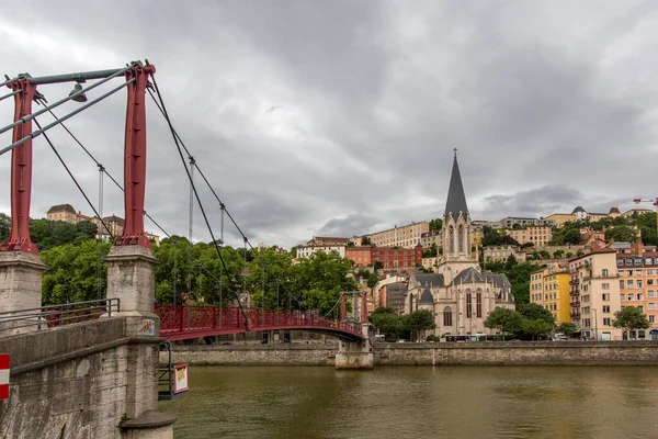 Church of Saint Georges and footbridge, Lyon, France. Panoramic view of Saint Georges church and pedestrian footbridge across Saone river, Old town with Fourviere cathedral.. — Stock Photo, Image