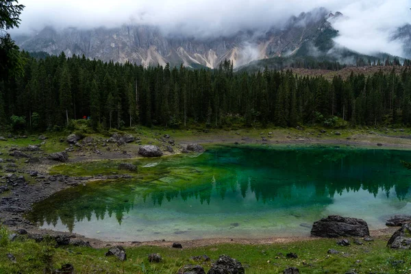 Kozalaklı ormanlarla çevrili kristal berrak göletin yansımasında Dolomitlerin resimli zirveleri. İtalya 'da Caresse Gölü. Manzaralı bir yer ve ünlü turistik bir yer. İlkel doğa.