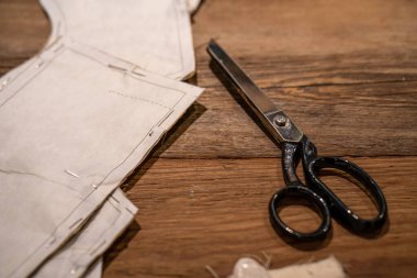 Makas, açık bej kumaşlı kağıt kesimi. Kesme işleminin yakın plan resmi. Dikiş dersi. Moda tasarımcısından model oluşturma atölyesi.