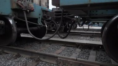 Trenin tekerlekleri raylara çıkıyor. Tren raylarındaki tren vagonları arasındaki bağlantı cihazını bağlıyorum. Yakın plan.. 