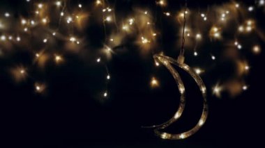Noel ağacı çelengi gece gökyüzü gibi parıldıyor. Ay yakında yükselecek. Gece gökyüzü ya da Noel çerçevesi şeklinde ışıklar..