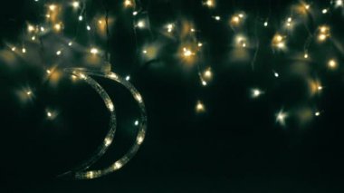 Noel ağacı çelengi gece gökyüzü gibi parıldıyor. Ay yakında yükselecek. Gece gökyüzü ya da Noel çerçevesi şeklinde ışıklar..
