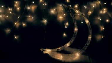 Noel ağacı çelengi gece gökyüzü gibi parıldıyor. Ay yakında yükselecek. Gece gökyüzü ya da Noel çerçevesi şeklinde ışıklar..