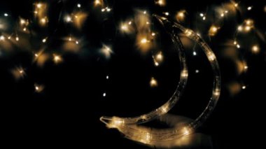 Noel ağacı çelengi gece gökyüzü gibi parıldıyor. Ay yakında yükselecek. Gece gökyüzü ya da Noel çerçevesi şeklinde ışıklar..
