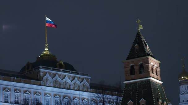 De vlag van de Russische Federatie wordt ontwikkeld op het rode plein. Op de voorgrond staat de toren van het Kremlin. Welterusten. — Stockvideo