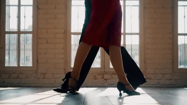 Close-up of the legs of a man and a woman dancing a pair of ballroom dance in the room. Dance moves of the tango. — Stock Video