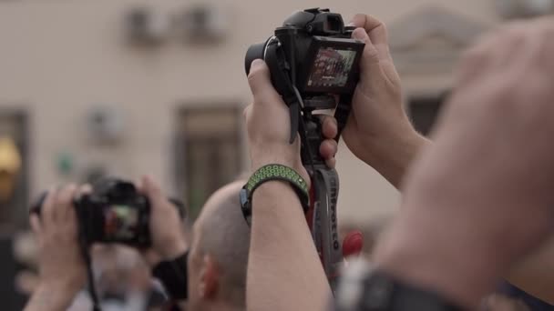 Fotografer på en sommardag fotograferar händelsen på gatan. Sommar. Närbild av händer. — Stockvideo