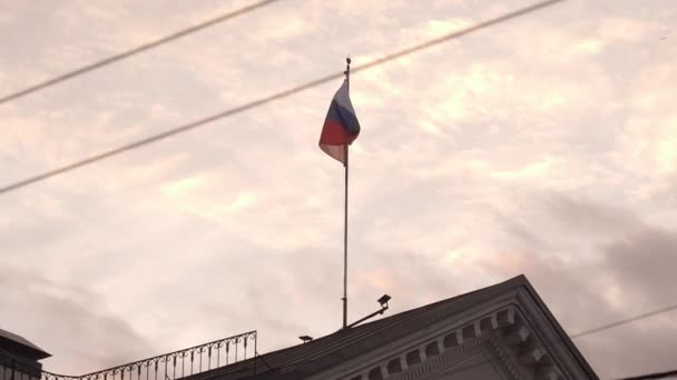 Российский флаг развевается над крышей старого здания. Вечер . — стоковое видео