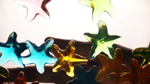 Aşağıdan bir el yapay renkli denizyıldızını dökerken görüntüyü al. Site için arka plan, tatil. — Stok video