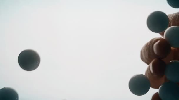 Vue d'en bas comme la main lance de petites boules en plastique multicolores. Fond blanc .