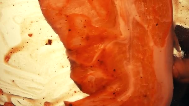 Uitzicht van onderaf als een kookborstel smeert ketchup met kruiden voor het koken biefstuk op de grill. Witte achtergrond. — Stockvideo