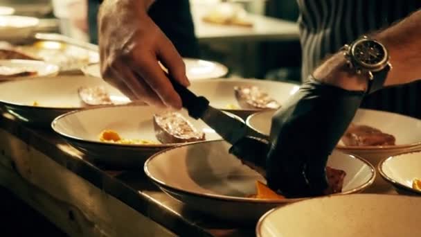 Wylewa żółty sos na ryby lub mięso. Żółty sos jest wylewany na stek rybny w talerzu fajansa. — Wideo stockowe