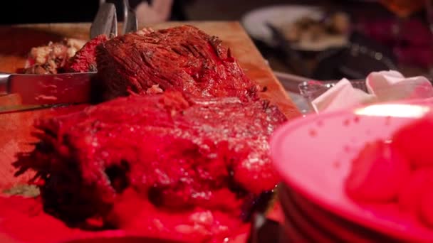 Close-up de como os chefs cortam a mão e cortam a deliciosa carne cozida. Iluminação vermelha, vida de clube . — Vídeo de Stock