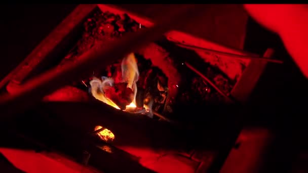 Oigenkännlig person som smider ett blad drar ut en het metallbit ur den brinnande november. — Stockvideo