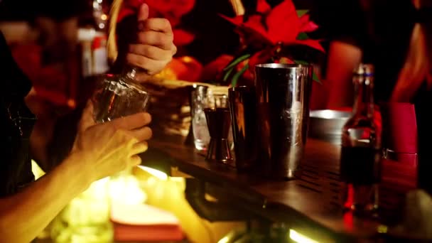 Een klassieke barman schenkt mousserende wijn uit een hoog glas in een cocktailglas in het interieur van een stijlvolle bar. — Stockvideo
