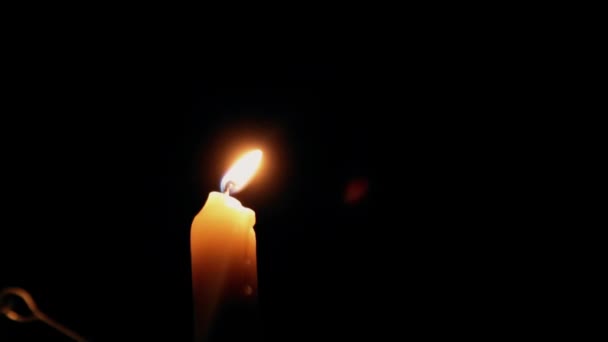 Beautiful fire of a candle in a dark room, a warm yellow candle quietly burning in the dark. — Stock Video