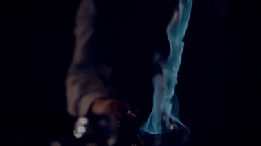Cooking a burning punch or grog, close-up. A fiery stream pours from cup to cup. The footage is recorded at 60 frames per second, and you can slow it down.  